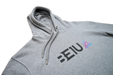 Grey hoodie zoomed view of chest and hood with black BE1U chest text and colour logo